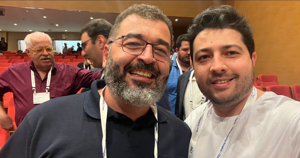 Dois homens sorrindo em auditório