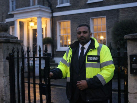 An illustrative image of a security officer standing outside of a residential property