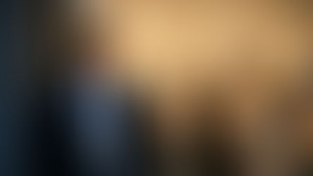 An illustrative image of a security guard standing near a shop entrance towards end of day