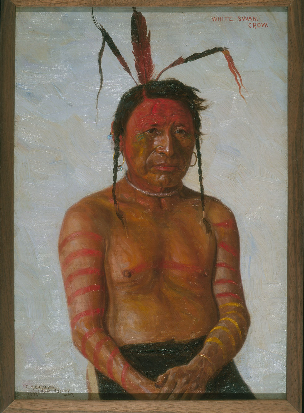 Portrait of a Crow warrior. The three feathers in his hair represent three wounds he received at the battle of Little Bighorn. The red rings painted on his arms represent the number of Sioux he has killed, and the yellow rings represent the number of Chey.