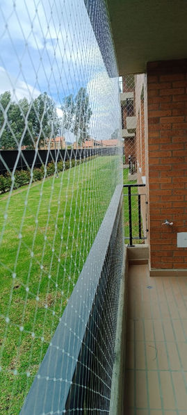 Balcón protegido con malla de seguridad resistente.