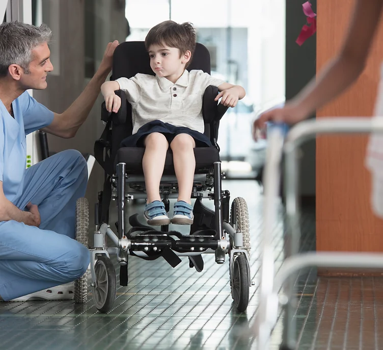 Doctor hablando con niño en silla de ruedas.webp