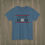 Thumbnail: Indigo blue Lacrosse Mom T-shirt with bold lettering and crossed lacrosse sticks featuring a USA flag design