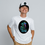Thumbnail: Man wearing a white colored Alien smoking from a bong graphic T-shirt with trippy cosmic background – Healey Threads apparel.
