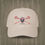 Thumbnail: A stone colored Retro Canadian Lacrosse baseball cap with crossed sticks, maple leaf mask, and vintage design
