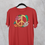 Thumbnail: A red colored t-shirt with colorful floral peace sign graphic design by Healey Threads hanging