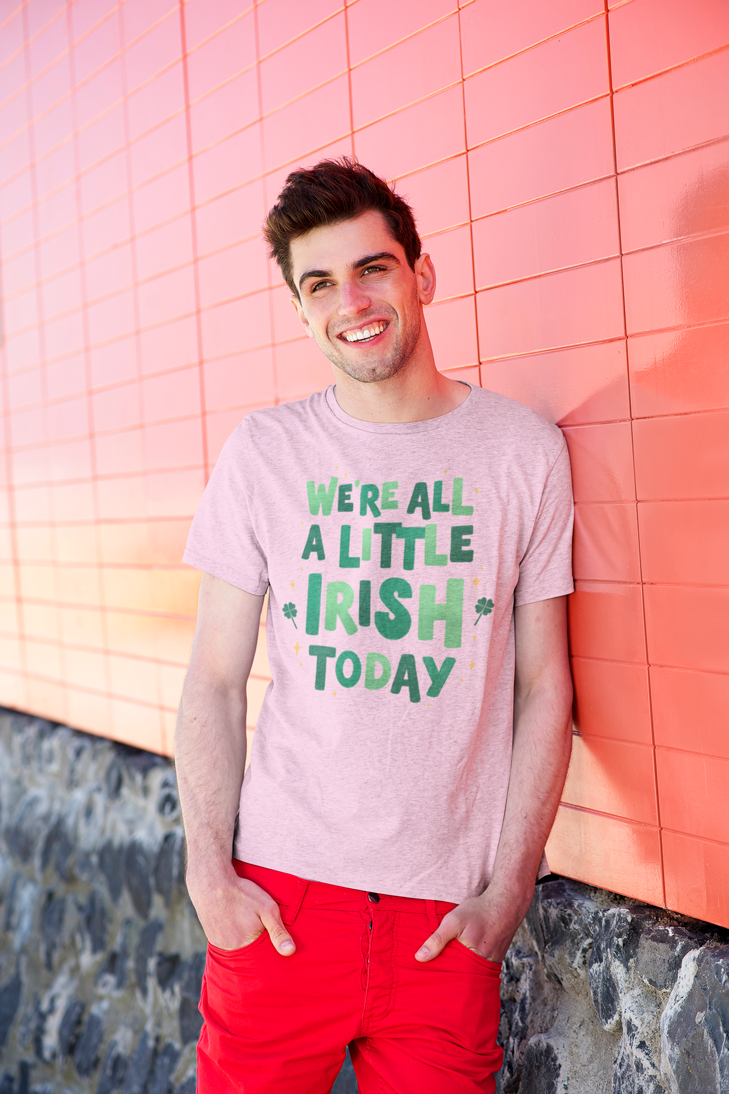 Man wearing a white t-shirt with a green graphic that reads We're All A Little Irish Today with small shamrock accents