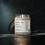 Thumbnail: Natural Soy Wax Candle in Clear jar with white label, black text, with black lid off, lit and on counter