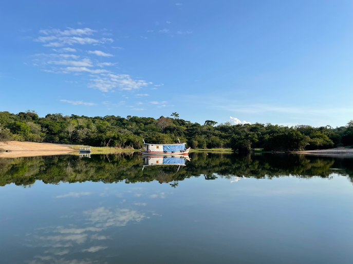 Horizonte amazônico com águas calmas e barco centralizado