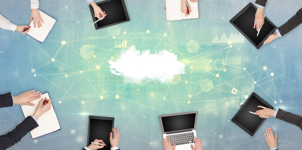 Group of people with devices in hands working on reports with online teamwork and cloud technology concept