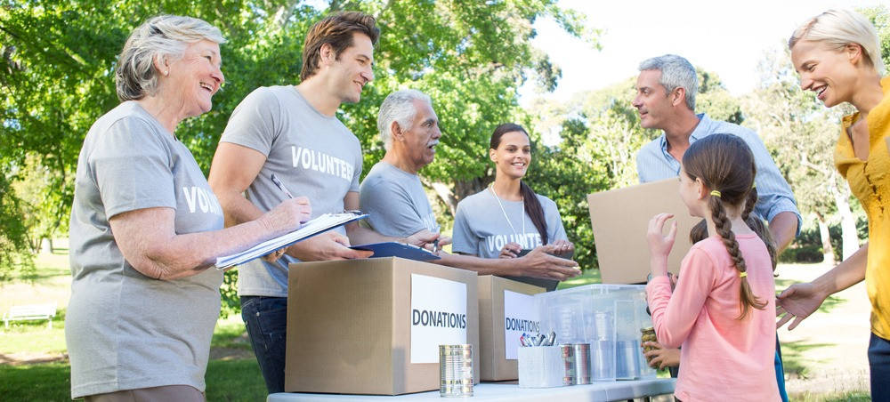 Happy volunteer family separating donations stuffs on a sunny day