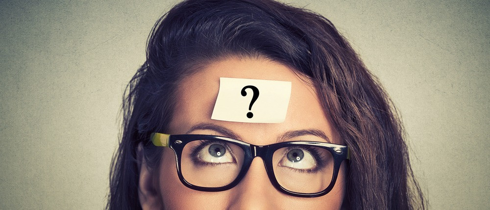 thinking woman with question mark on gray wall background