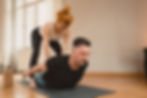 Personal Yoga Training Dresden: Ein Personal Yoga Training bringt viele Benefits mit sich. Das Beste ist - du allein stehst im Mittelpunkt, du kannst dich ganz auf dich konzentrieren und so in den Kontakt mit dir treten. Auf dem Foto ist Yogalehrerin Carolin Rieck bei der Unterstützung eines Kundens in der Heuschrecke (Shalabhasana) abgebildet.