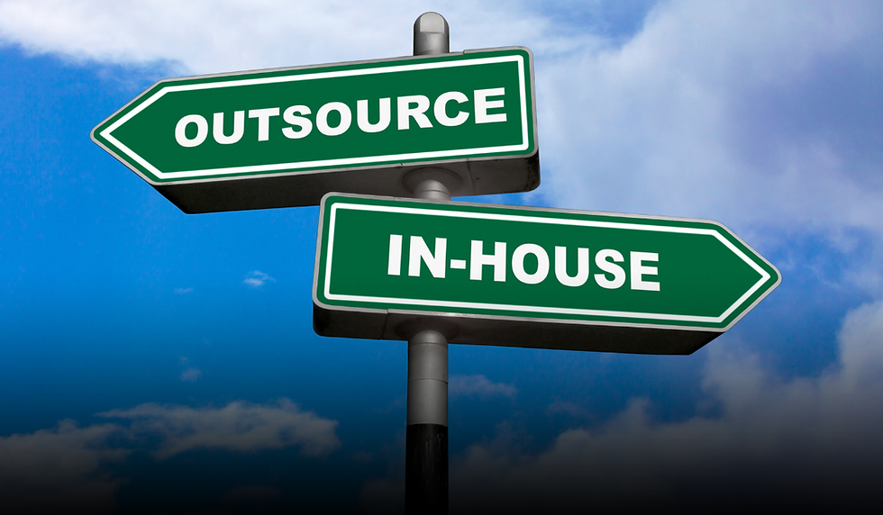 A road sign with two green directional arrows pointing in opposite directions; one labeled "OUTSOURCE" and the other "IN-HOUSE," set against a blue sky with scattered clouds. The image visually represents the decision-making process between outsourcing and hiring in-house for business operations.