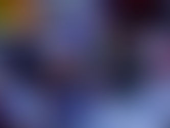 Colorful glass spheres on a reflective surface, displaying swirling patterns. Background is blurred with vibrant hues. Peaceful and artistic mood.