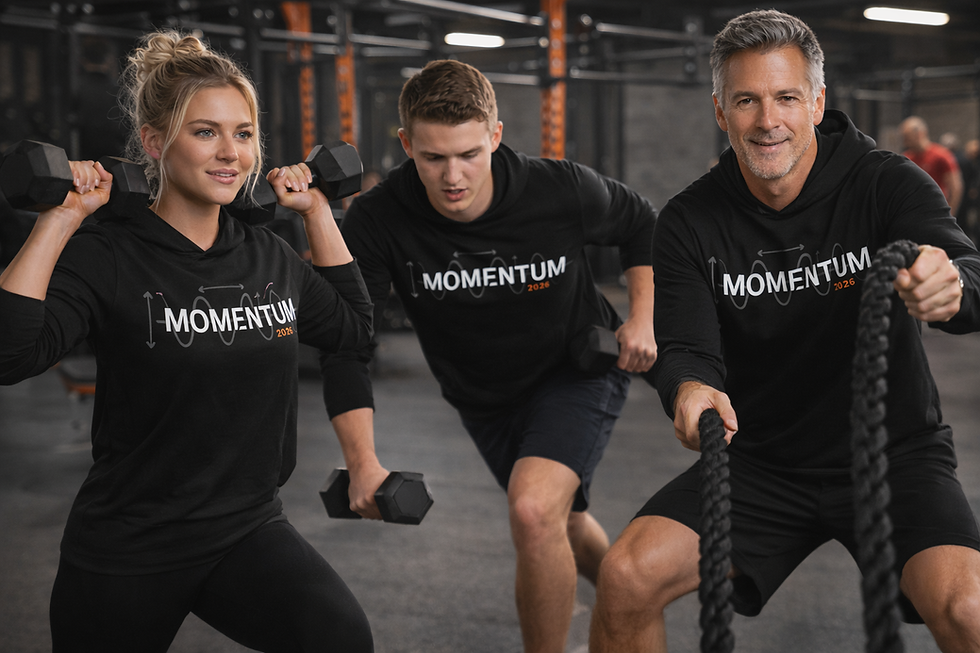 Three people exercising in a gym wearing black "MOMENTUM 2026" hoodies. One lifts weights, another lunges, and a third pulls ropes. Focused mood.