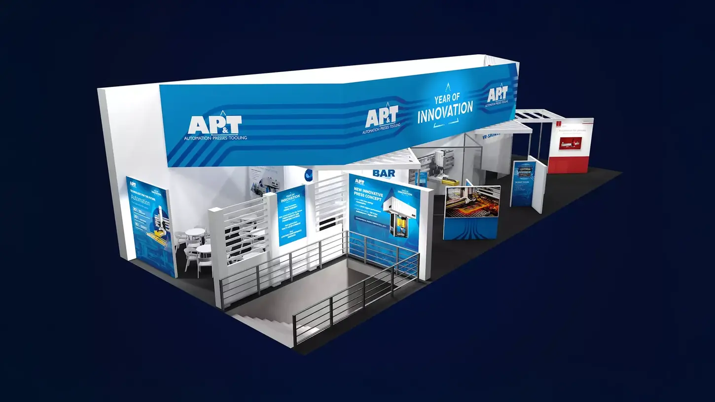 Översiktsbild av en mässmonter från AP&T med temat 'Year of Innovation'. Montern är inredd med informationsskyltar, en bar, sittplatser och digitala skärmar som visar företagets lösningar och innovationer inom automation och presskoncept.