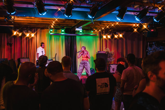 A small stage with performers and an audience