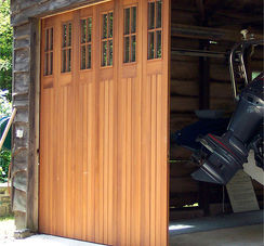 Custom vertical wood garage door with upper glass panels installed on a New Jersey home
