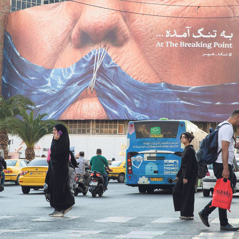 People walk past a new billboard depicting the closure of the Strait of Hormuz in Valiasr Square, Tehran, Iran, May 2, 2026. Shipping companies said President Donald Trump’s offer to provide them safe passage through the strait fell short of the sort of arrangements that would persuade them to make the trip. (Arash Khamooshi/The New York Times)