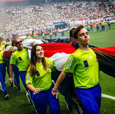 It takes coordination (and many arms) to unfurl a World Cup flag