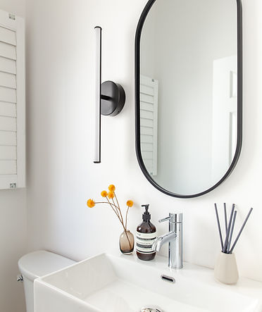 Stylish bathroom featuring a large mirror with rounded corners.