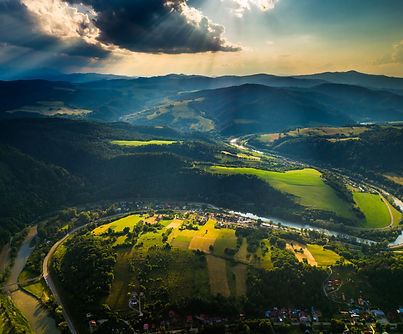 The sun rays over the Poprad River and Beskid Sadecki (Polish_ Beskid Sądecki) mountains i
