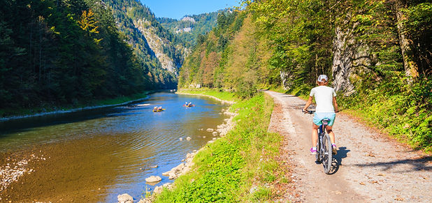 Young woman cycling along Dunajec river on sunny autumn day, Pieniny Mountains, Poland.jpg