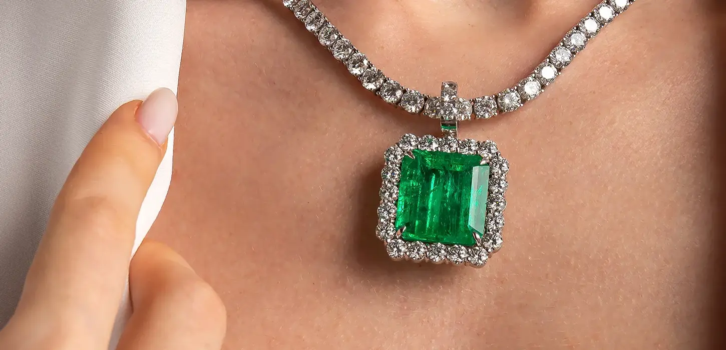 Fotografia de modelo posando com colar de esmeralda da loja Sara Joias.