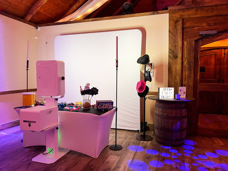 A wedding Photo Booth setup with a white backdrop,  props and a well-organized accessories table, ready for guests to capture fun memories at the event.