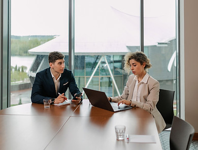 two people meet at desk with laptop