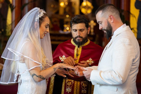 A priest presiding over the marriage of a man and woman as they exchange rings