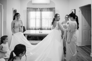 bridesmaids helping bride with dress