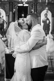 Bride and groom embrace in front of a church after tying the knot.