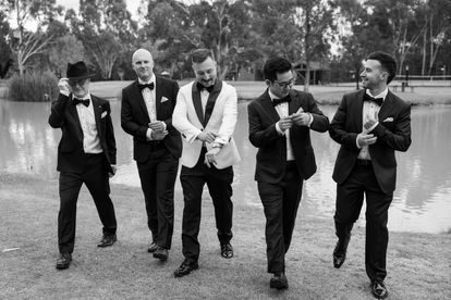 Candid moment between the groom and his groomsmen during relaxed wedding preparations in Moama.