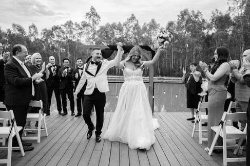 Black and white of Bride and groom walking back down the aisle together after the ceremony.