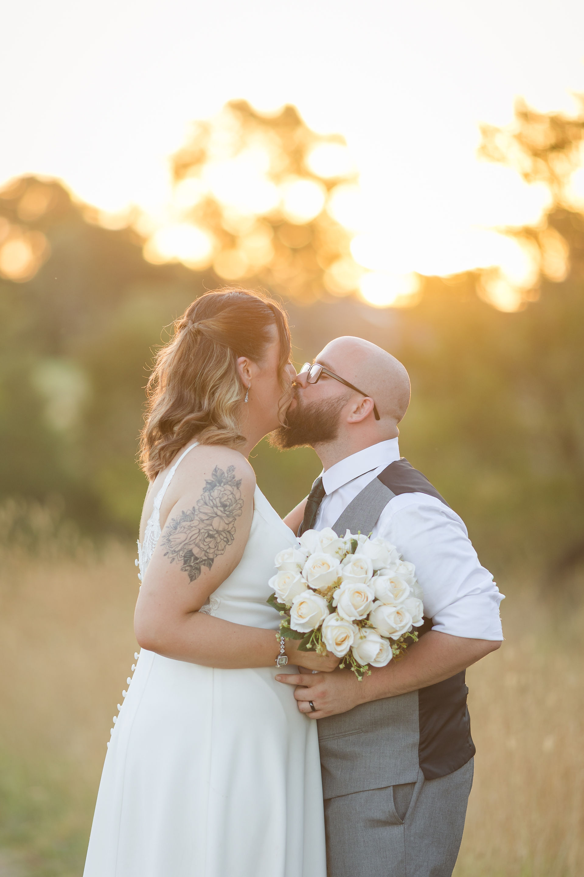 Bride and groom embracing in golden hour light over the golf course at Craigieburn Sporting Club captured by Melbourne Wedding Photographer.