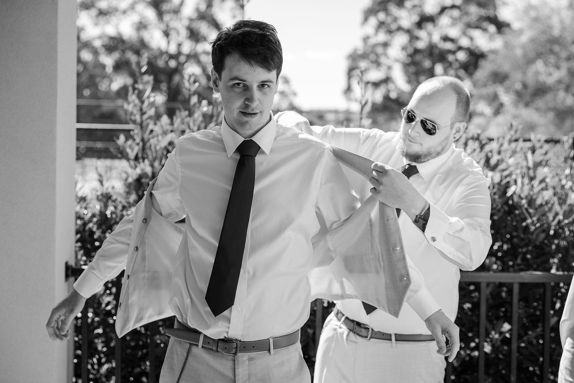 Groom laughing with groomsmen while getting ready before wedding ceremony