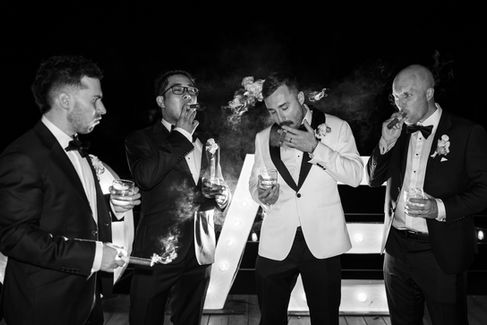 Groom enjoying a quiet moment with a cigar after the reception celebrations.