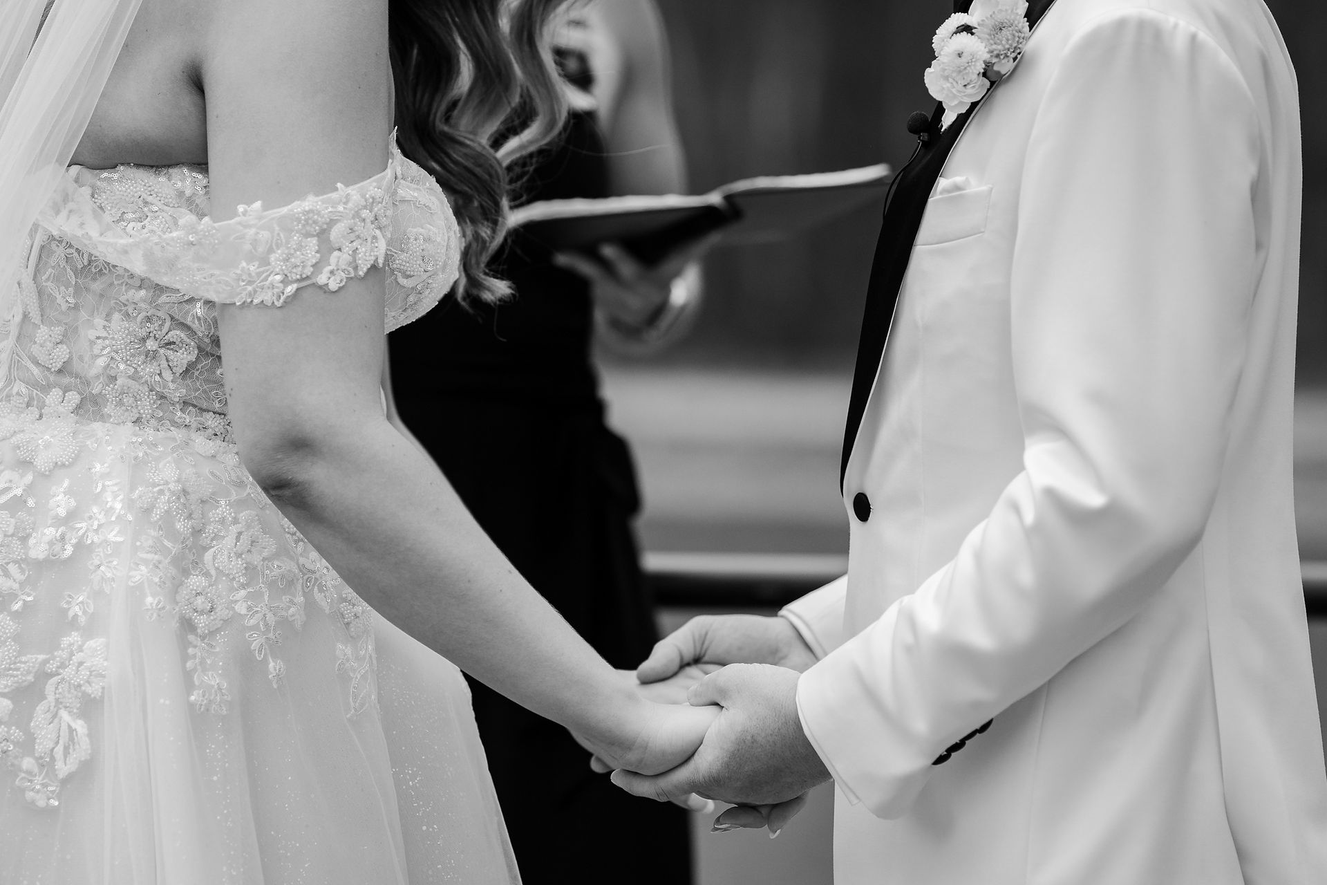 Close-up of the couple holding hands during the wedding ceremony.