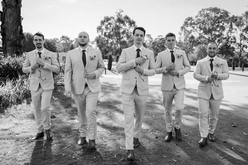 Black and white photo of groom getting ready with best man