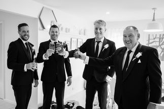 groom and groomsmen having celebratory drink