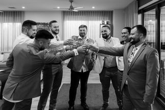 groom and groomsmen having cheers pre drinks