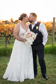 Bride and groom sharing a kiss under warm sunset light