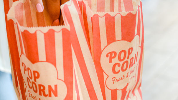 Person holding popcorn bags