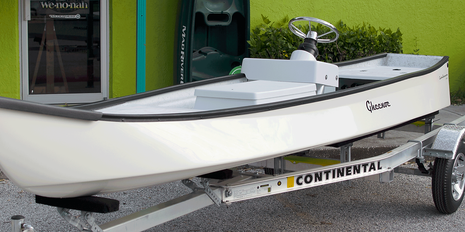 Custom Gheenoe LT10 on trailer in front of shop. White with center console.