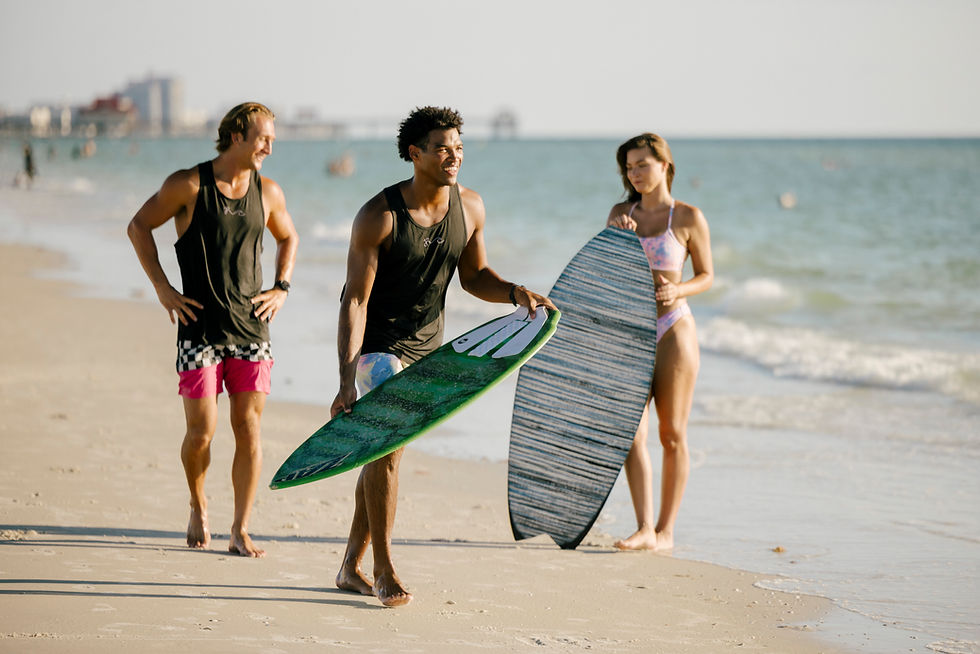 Two people with skim boards and one watching, one person is ready to start running