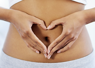 woman making heart shape with hands in front of tummy
