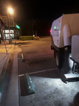 Image depicts parking lot sweeper truck cleaning dirt and debris from parking lot showcasing Pacific Commercial Property Services’ professional exterior maintenance at a retail, industrial, or office complex in Temecula, Murrieta and surrounding areas.