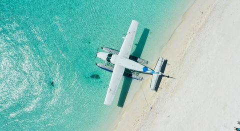 A photo from above of a seaplane parked at a Bahamas beach